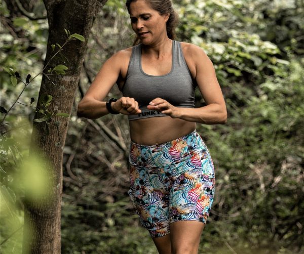 Photo of women running with her all terrain running shoes in the bush.