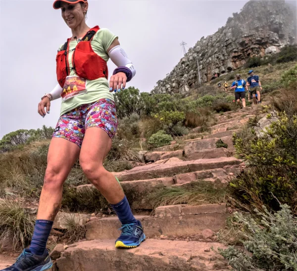 Photo of a young women using trail running gear on an outdoor trail.